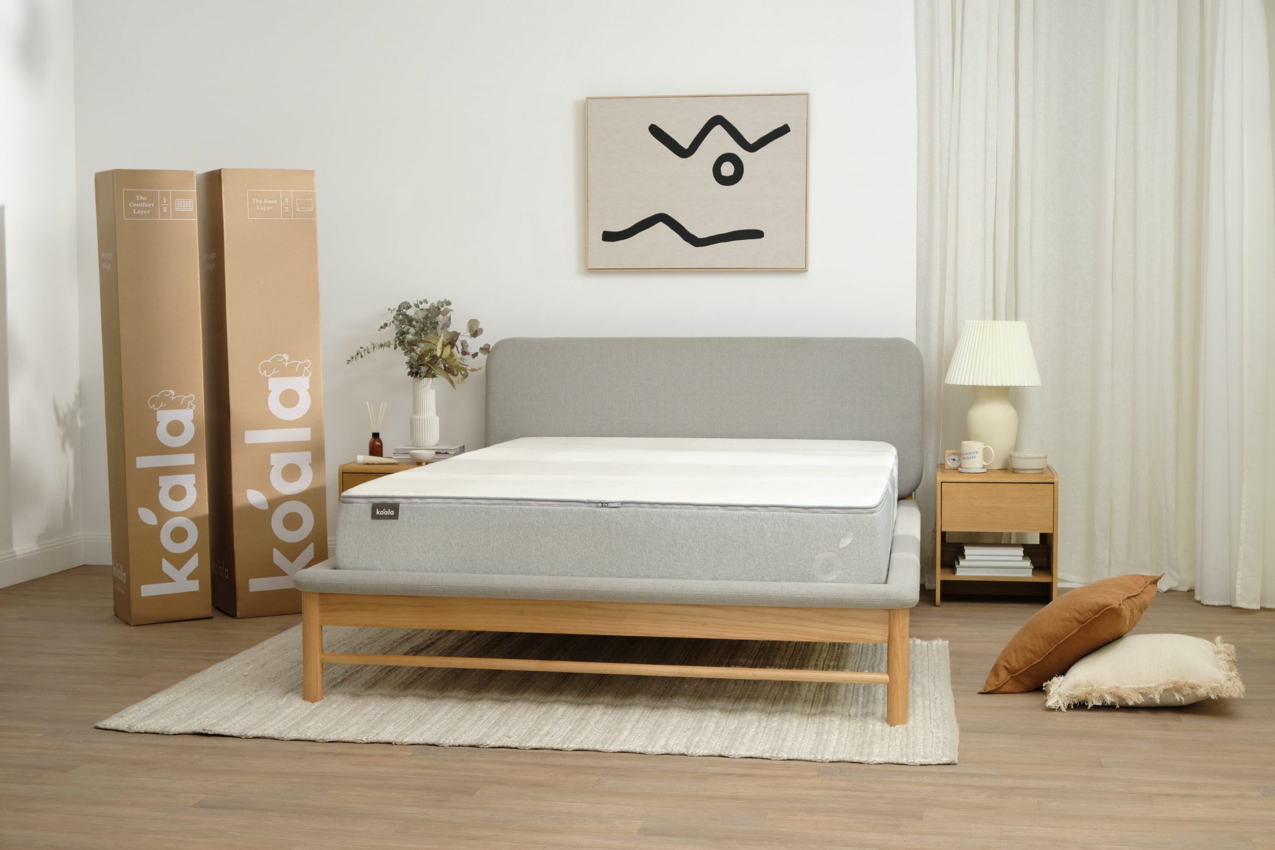 A Koala mattress on a bed next to a Koala mattress delivery box after someone has bought the mattress online