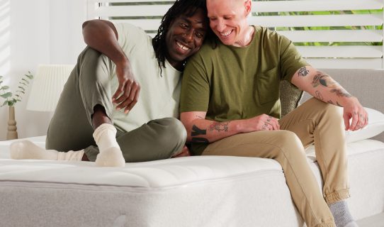 Two happy men sitting on their new Koala mattress discover just how good the mattress is