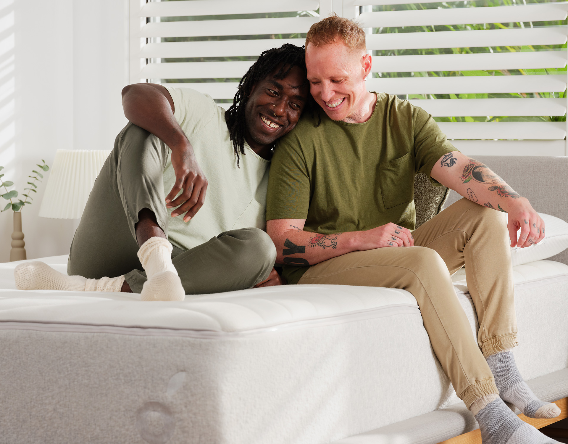 Two happy men sitting on their new Koala mattress discover just how good the mattress is
