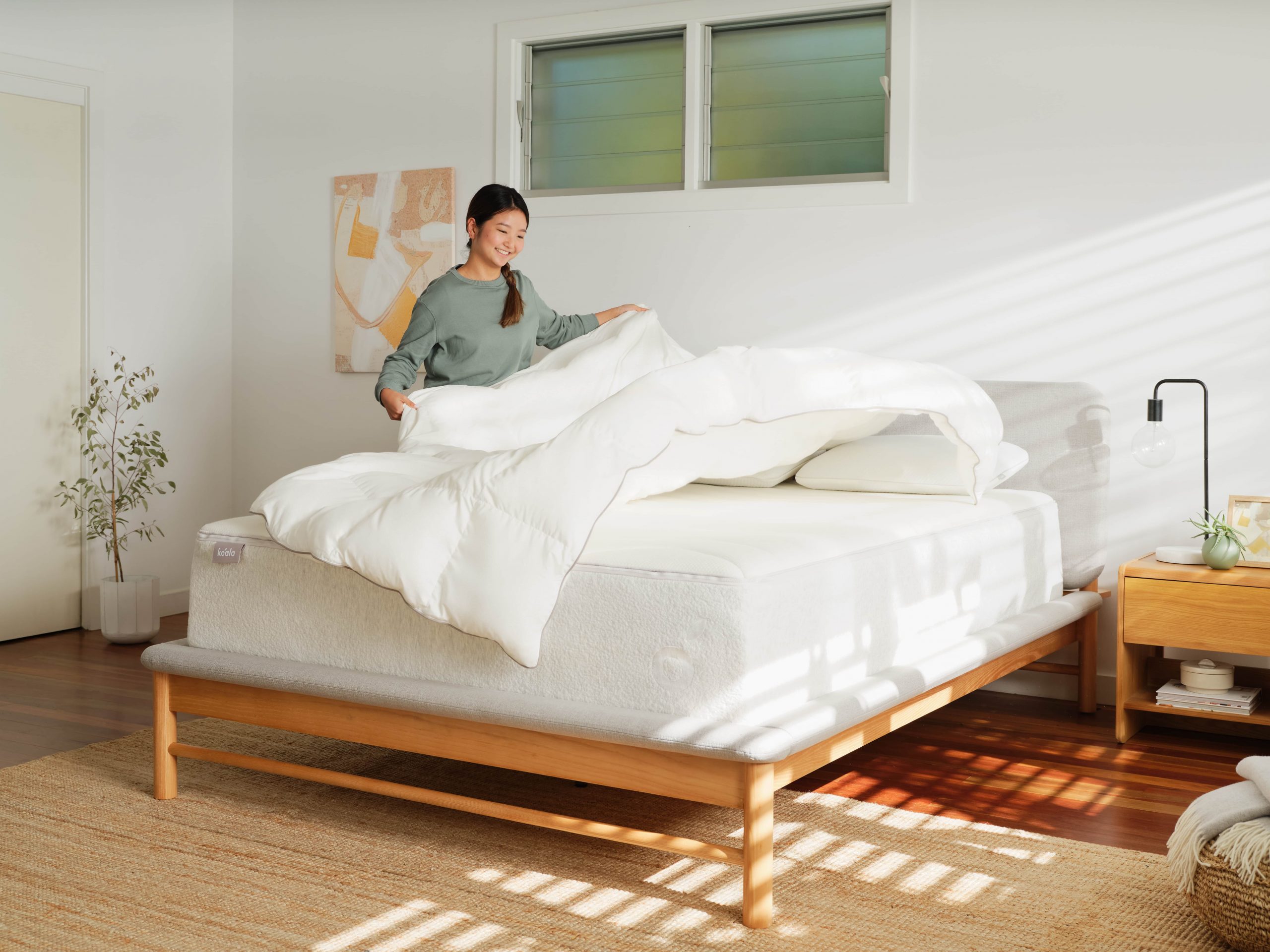 The best bedtime routine for adults involves winding down and preparing yourself and your bed for a comfortable sleep, as this woman is doing in her bedroom