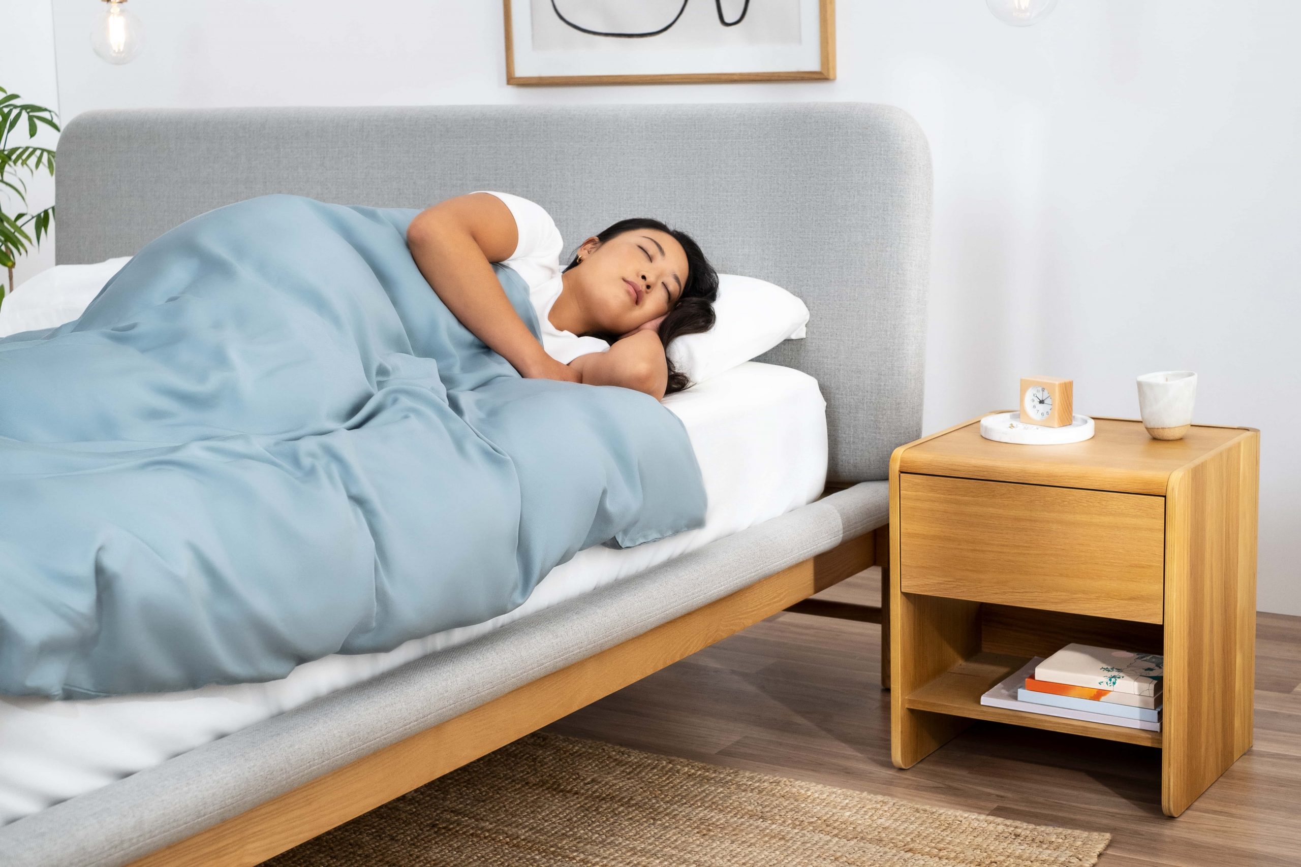 A woman sleeps soundly in her mid-century modern bedroom with Koala furniture