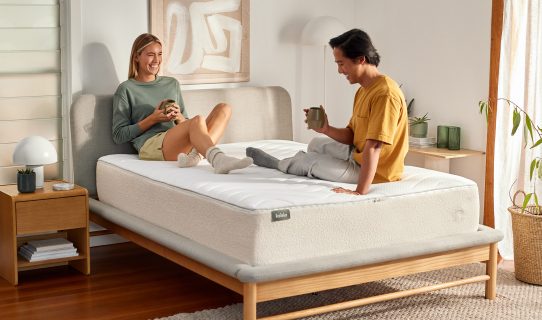 Smiling couple on a springless Koala mattress discovering that foam mattresses are just as good as pocket spring mattresses