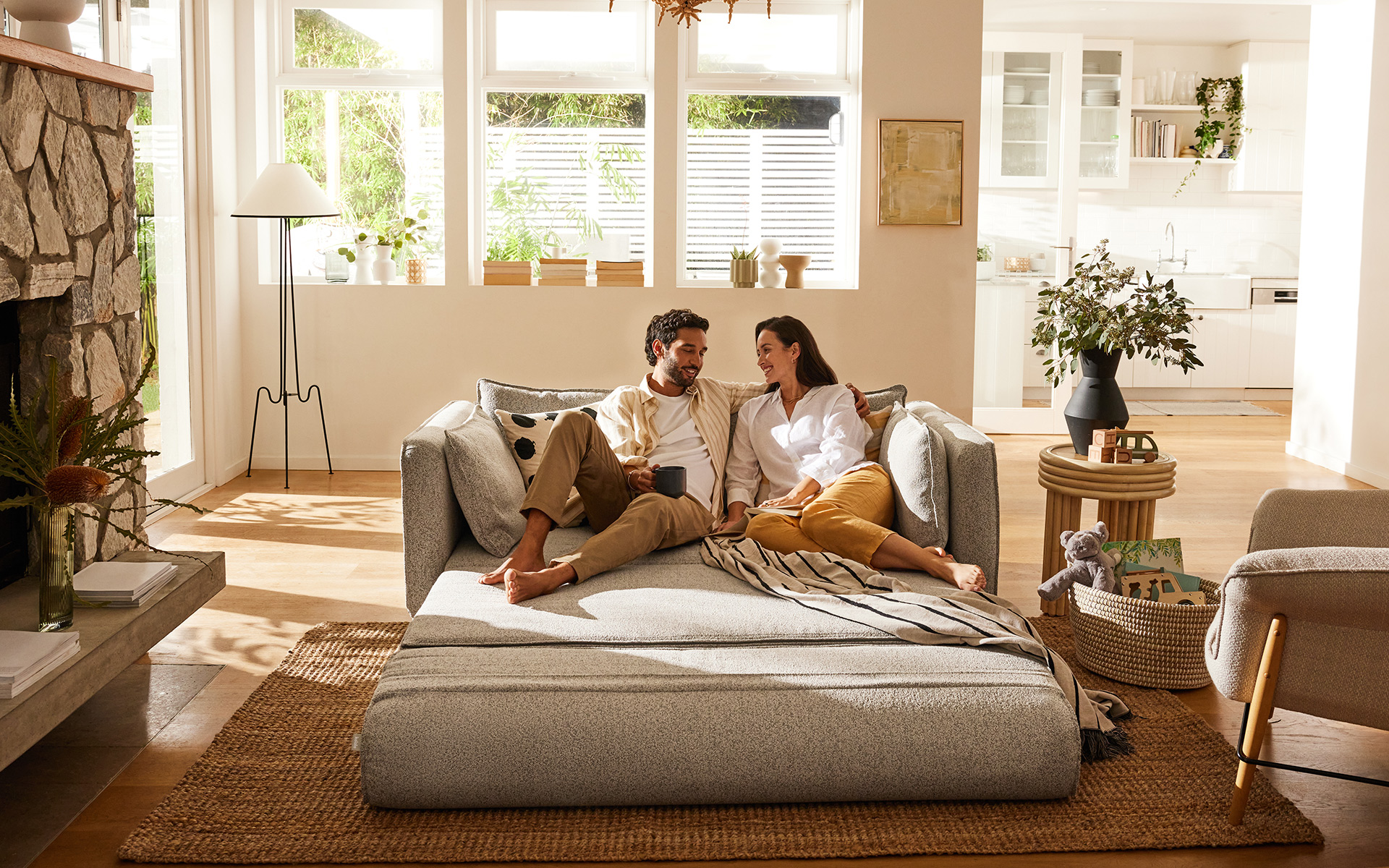 A couple relax on a beautiful Koala sofa bed, in their bright and beautiful lounge room