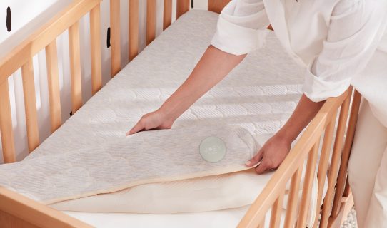 A woman replaces the protective cover on her baby’s Koala cot mattress
