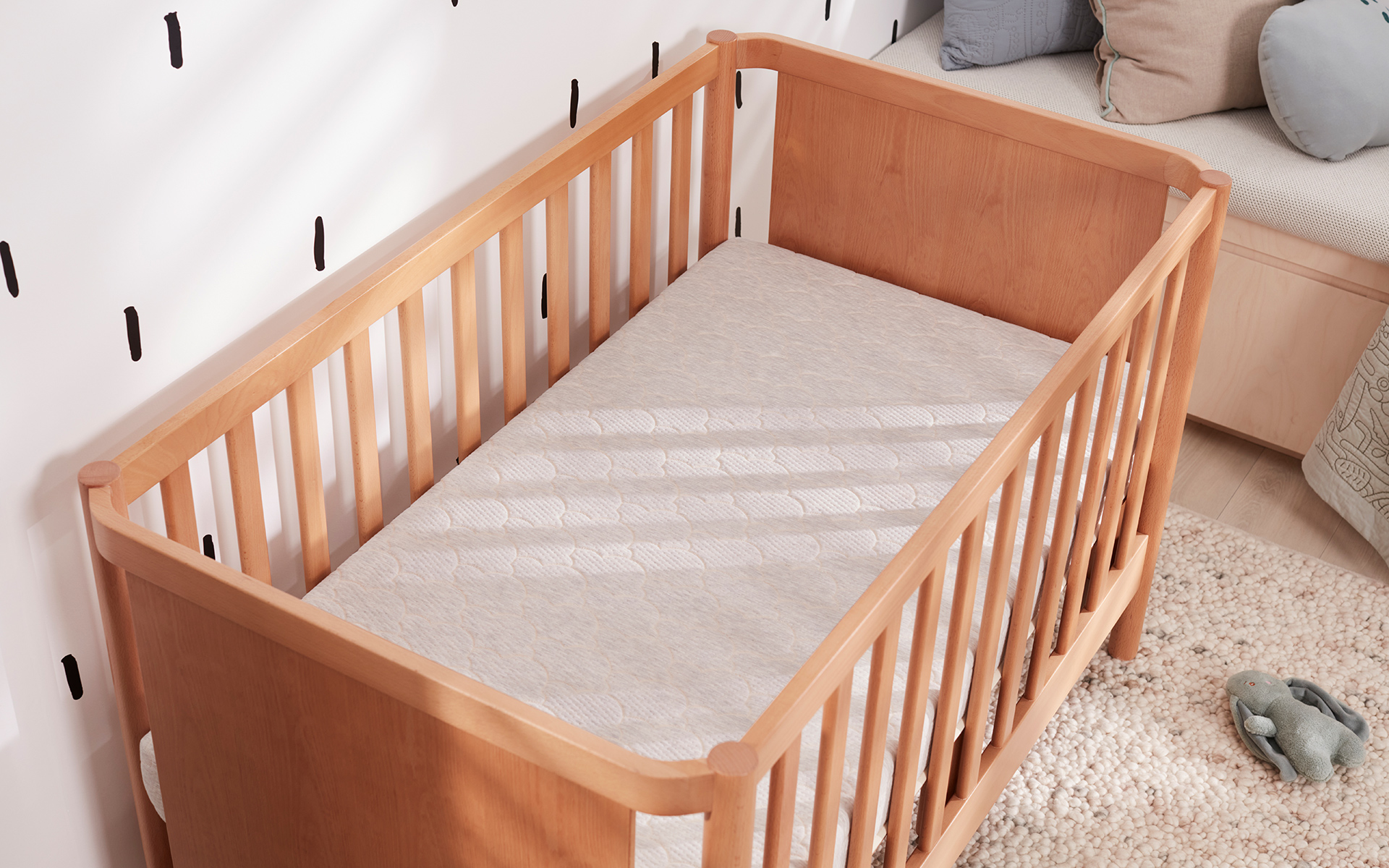 A Koala cot and mattress without a cot mattress topper, in a beautiful designed room
