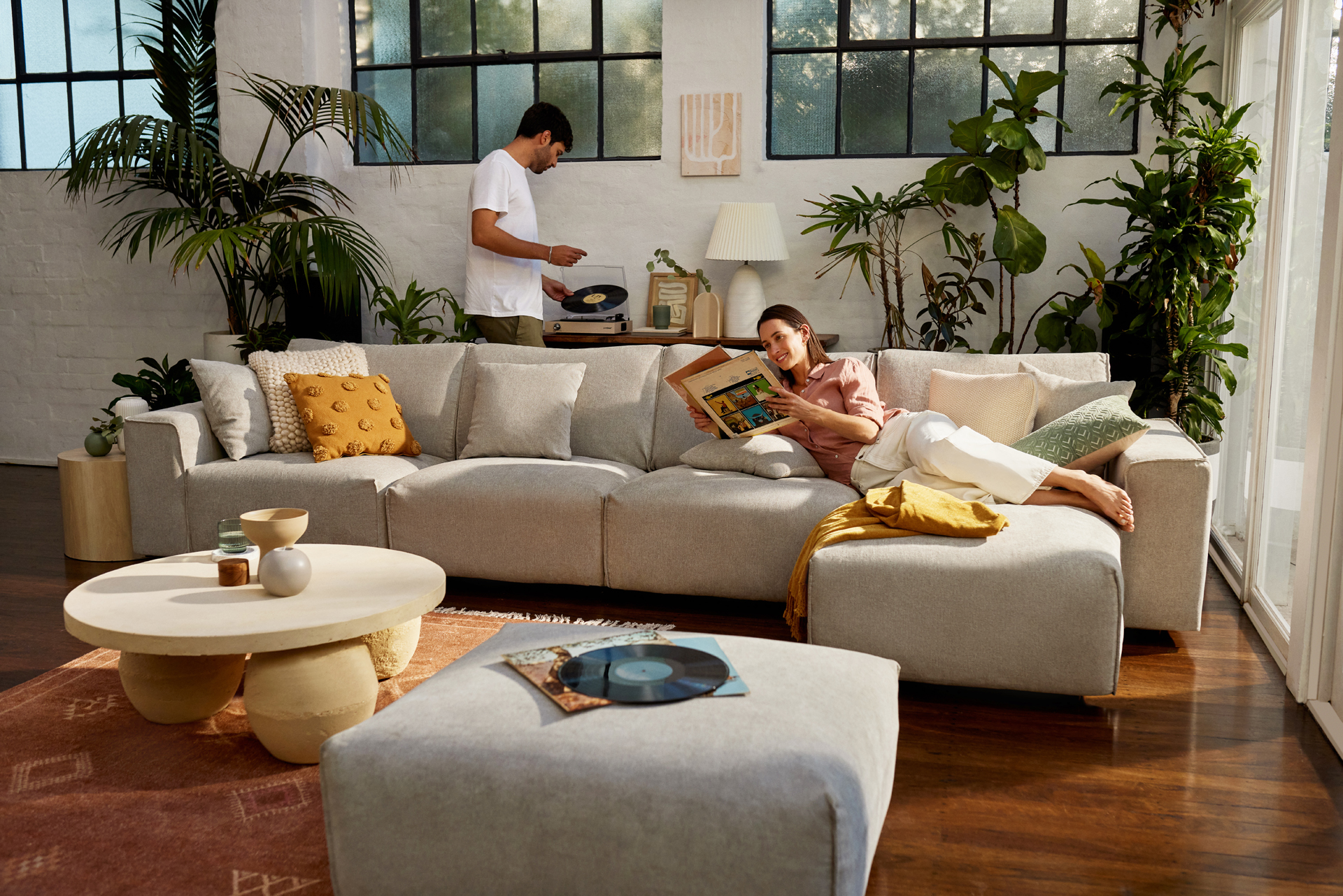 A couple relaxes in their large living room with a generous Koala sofa and ottoman