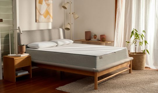 Koala mattress on a Koala bed frame in a roomy bedroom with timber floors, white walls and accessories
