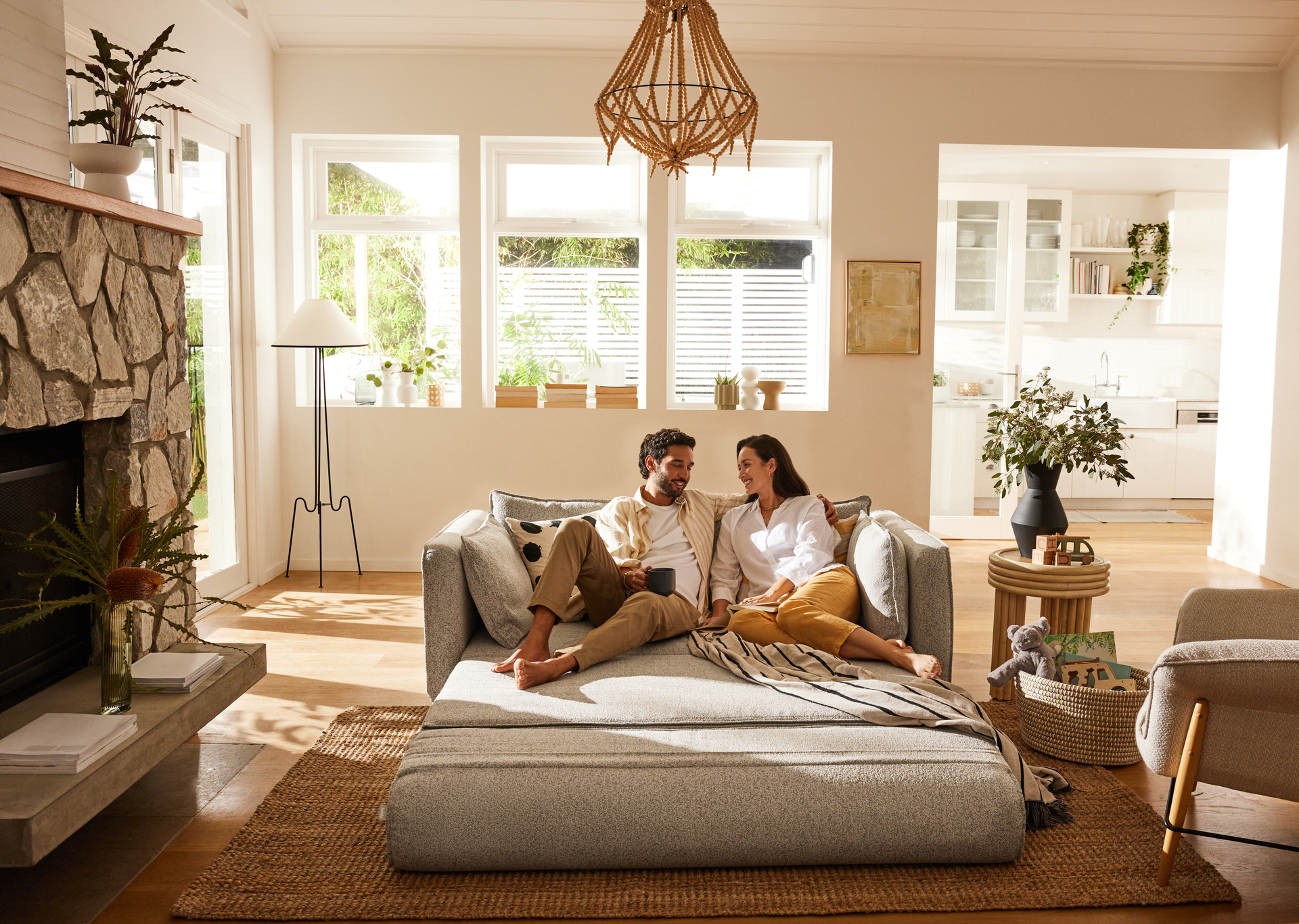 A couple relaxes on their 3-seater sofa bed, the Koala Cushy sofa bed, in their large lounge room